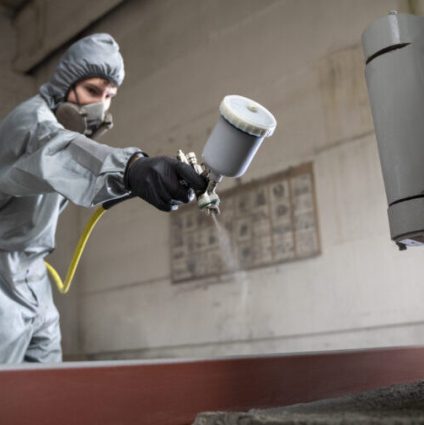 low-angle-man-spraying-powder-paint-from-gun